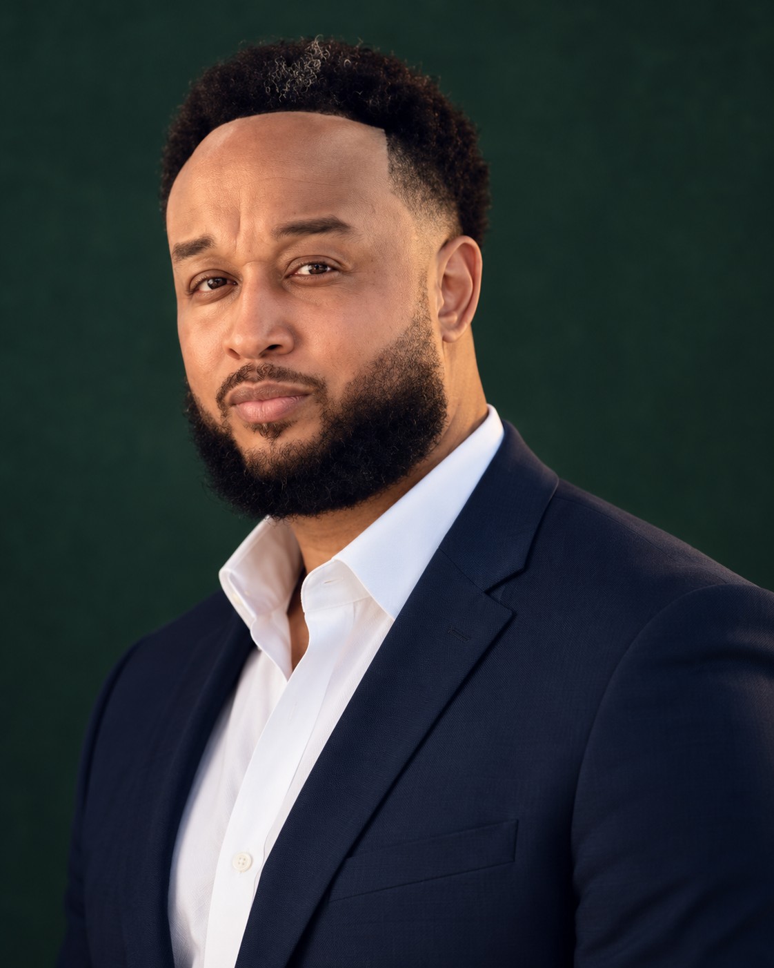Jurell Tanksley in a navy blazer and open-collar white shirt