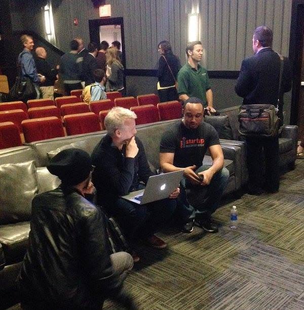 A conversation around an open laptop at a startup event